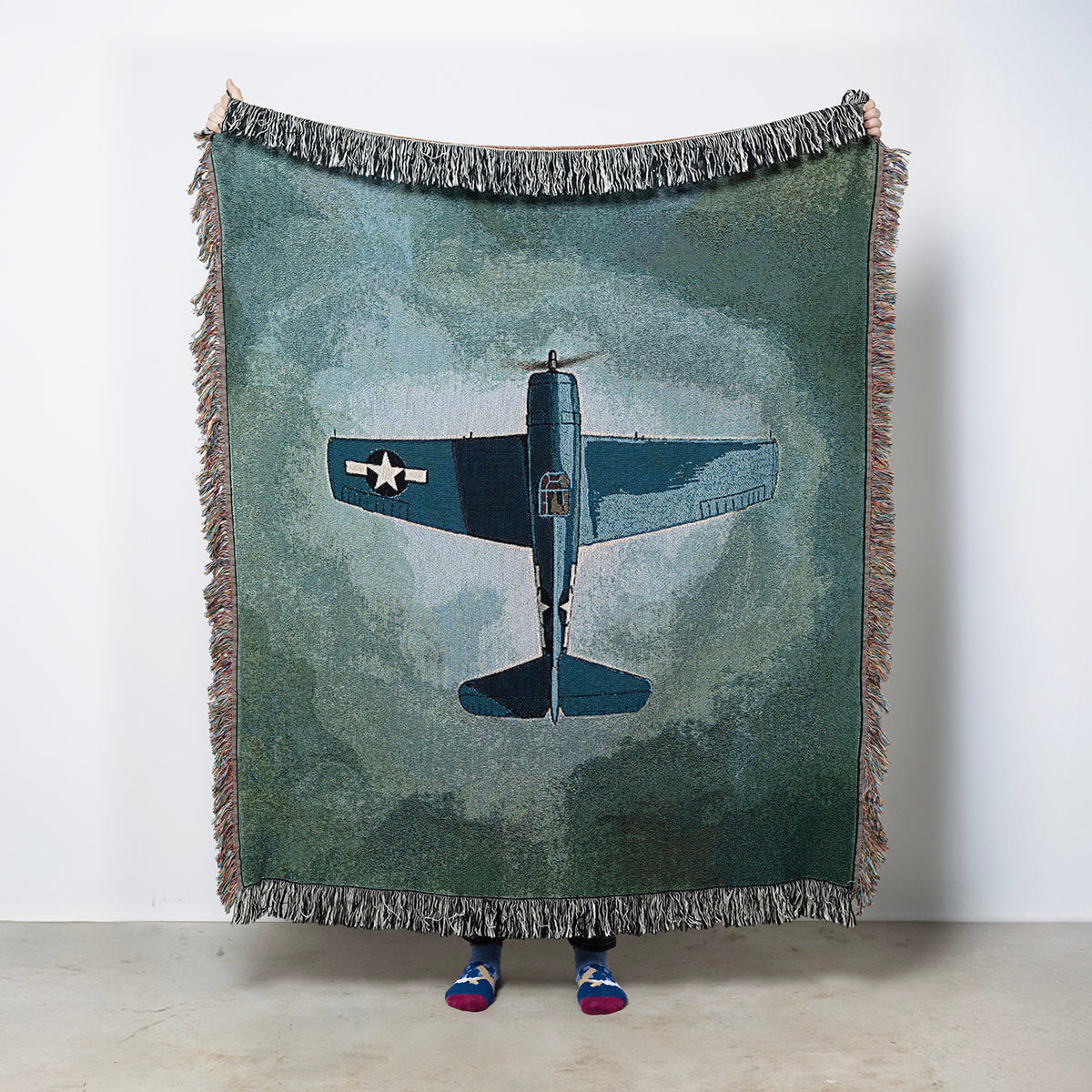 Woven blanket with a Grumman F6F Hellcat airplane on a blue green background
