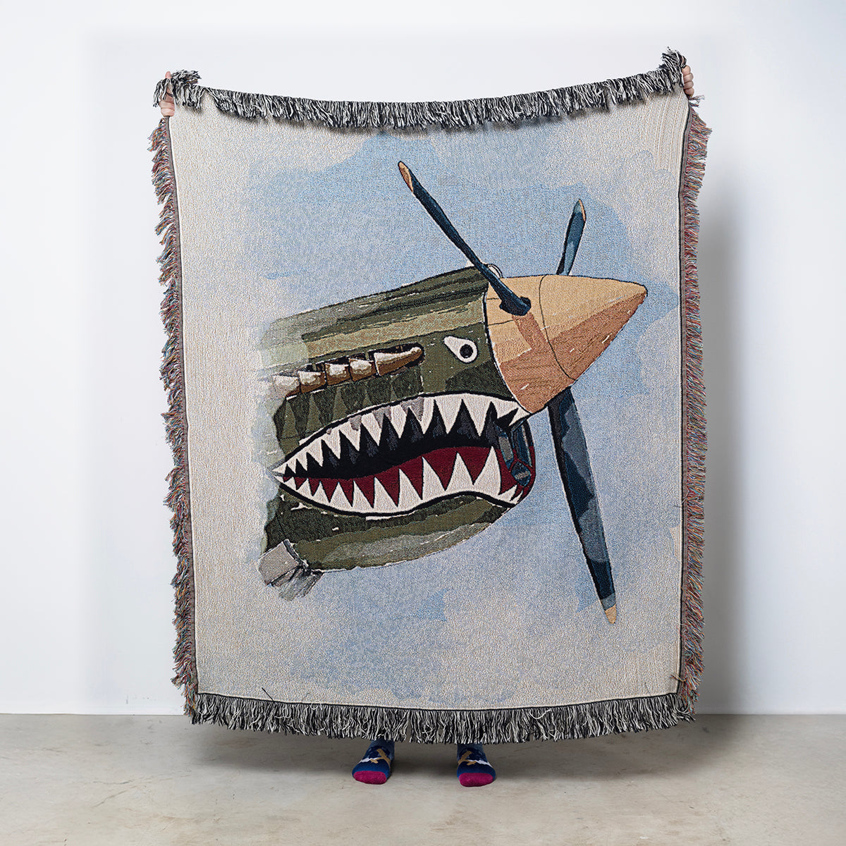 Woven blanket featuring the iconic P-40 Shark Mouth from WWII airplane nose art.