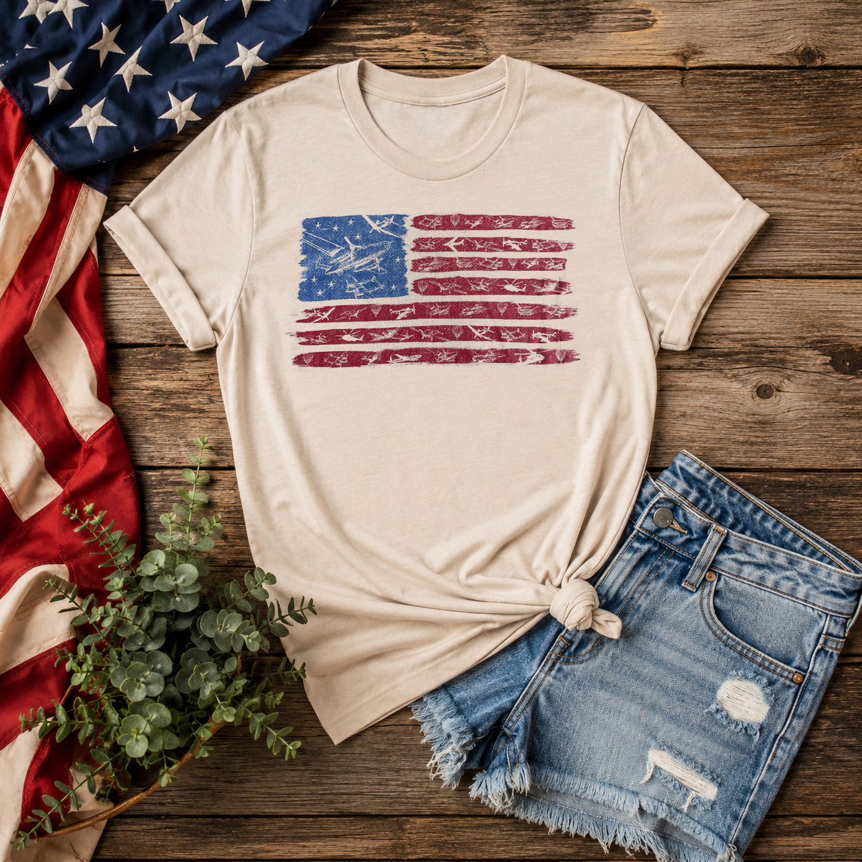 Beige Freedom to Fly aviation t-shirt featuring a patriotic American flag design with vintage aircraft artwork displayed against an American flag background.