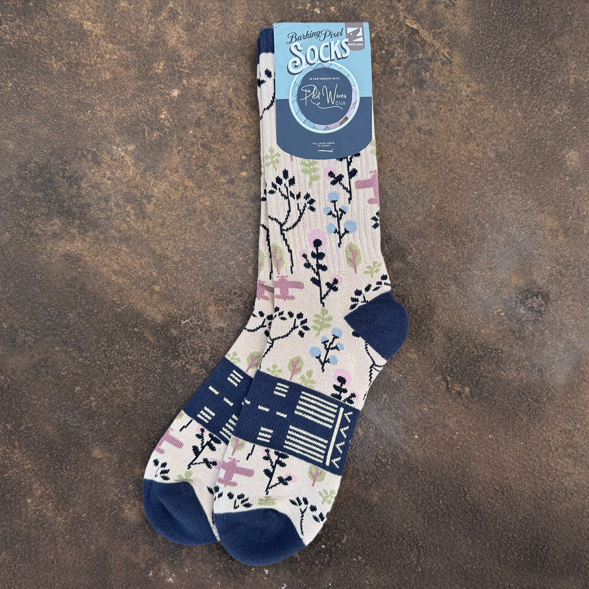 Ultra-soft cushioned aviation crew socks featuring airplanes, runway-inspired details, botanical accents in off-white and navy for pilots and aviation enthusiasts.