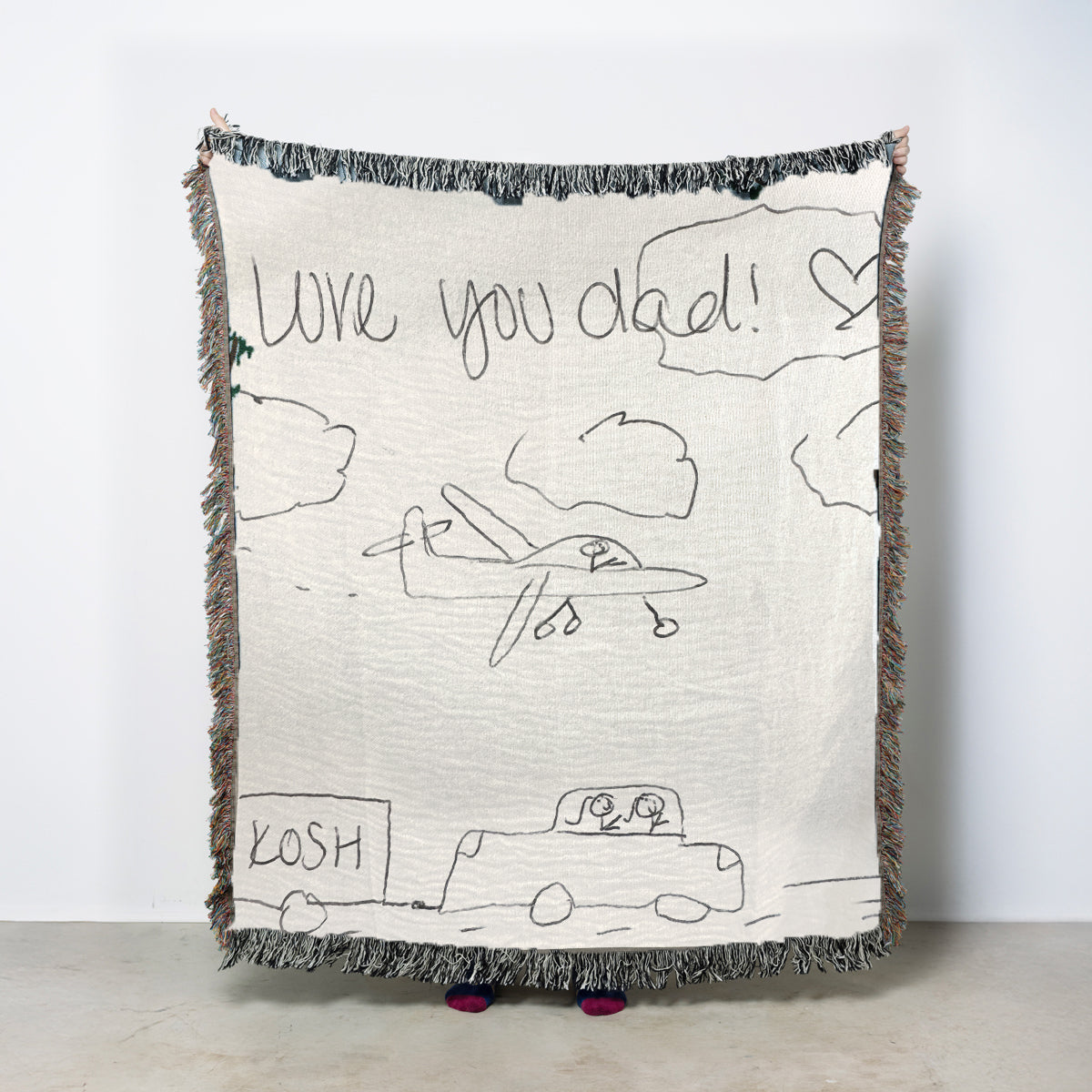 Blanket with child's drawing of a plane and text 'I love you dad!' on a white background