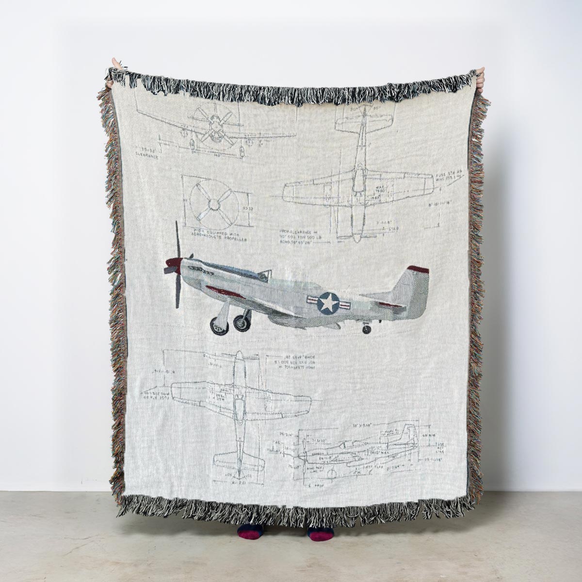 P-51 Mustang aviation woven blanket featuring an illustrated side view of the WWII fighter aircraft with blueprint-style technical drawings above and below the airplane.