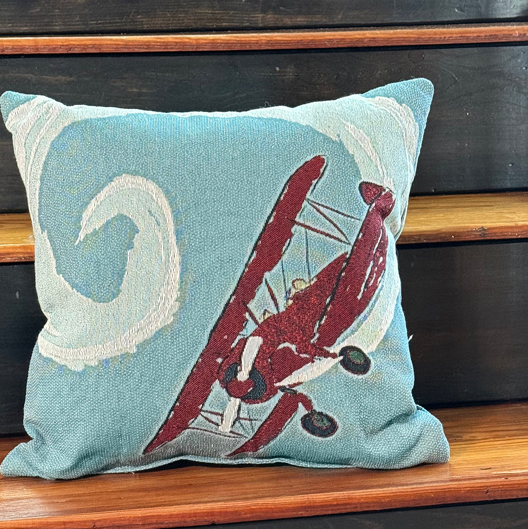 Woven throw pillow with aerobatic plane in sky