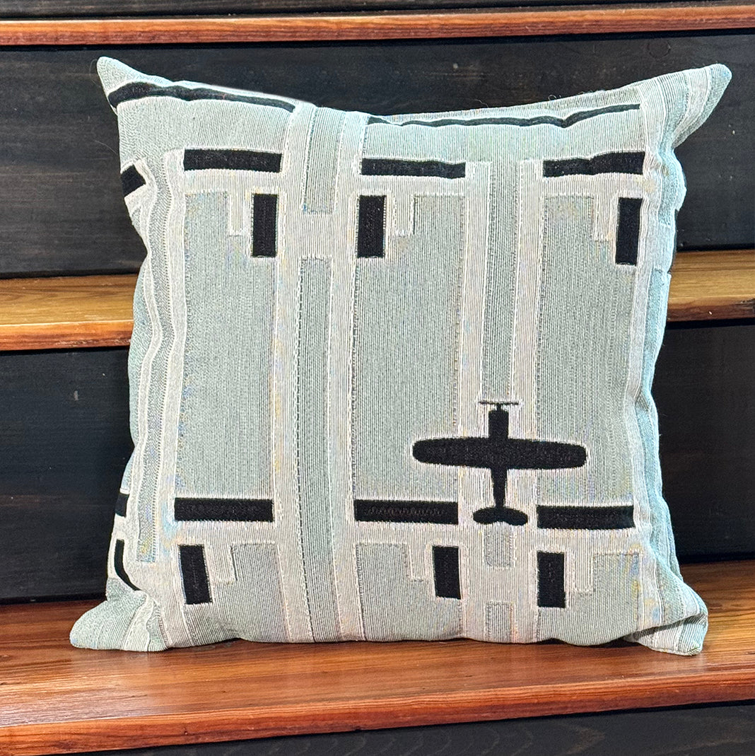 Woven throw pillow with airplane and geometric pattern