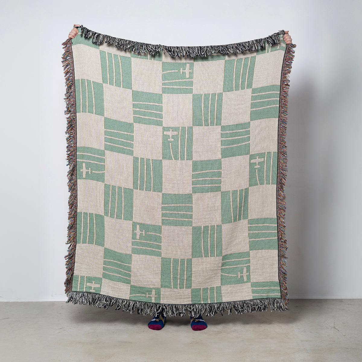 Checkered airplane blanket with green and cream pattern