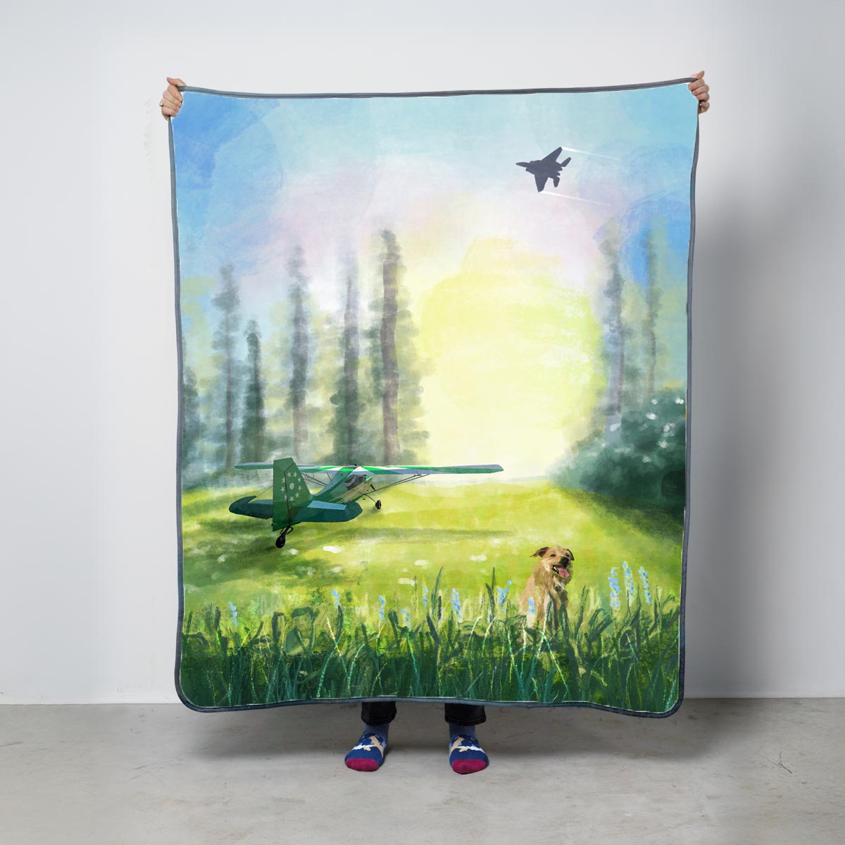Fleece blanket with a scenic design of a dog and airplane in a field with trees and sunrise