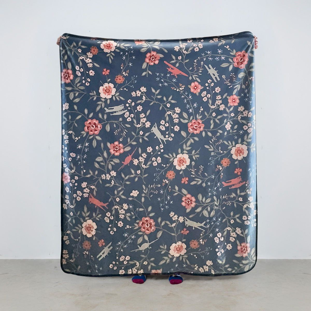 fleece blanket with floral pattern and general aviation airplanes on a blue background