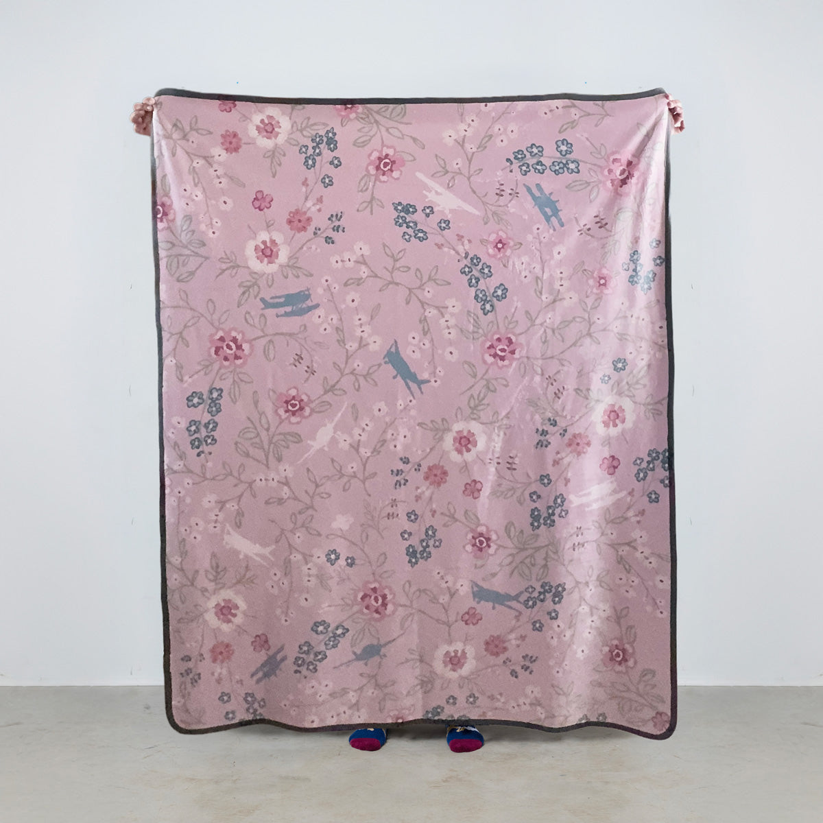 fleece blanket with floral pattern and general aviation airplanes on a pink background