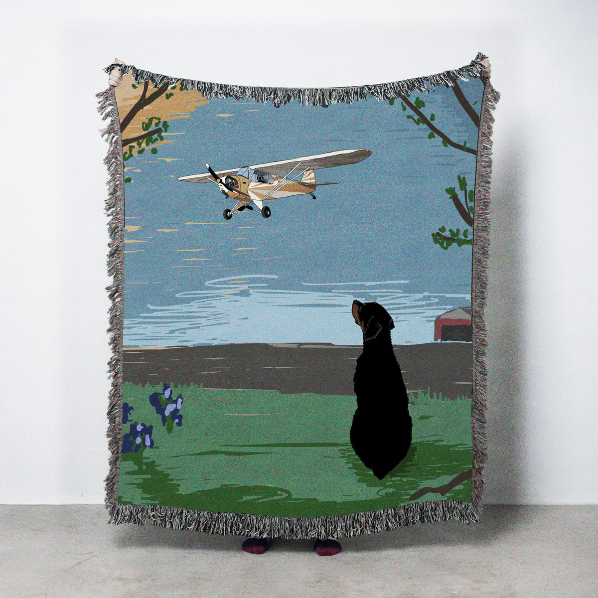 Blanket with a dog watching a plane fly over a field scene