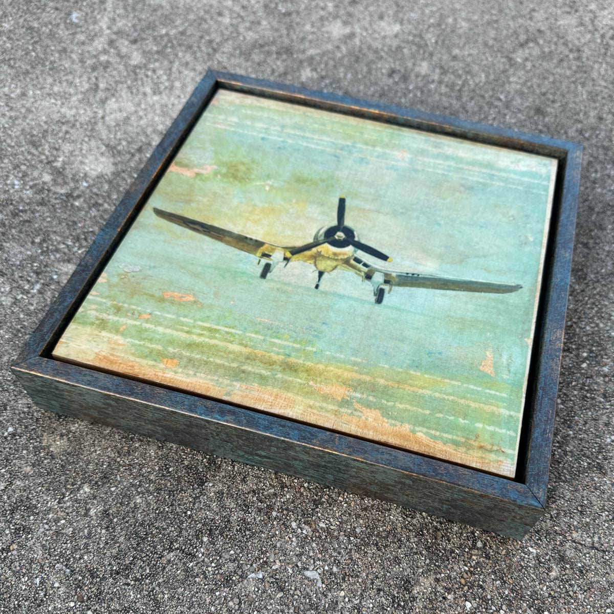 Framed digital art hand transferred to wood with a vintage corsair airplane design on a textured surface
