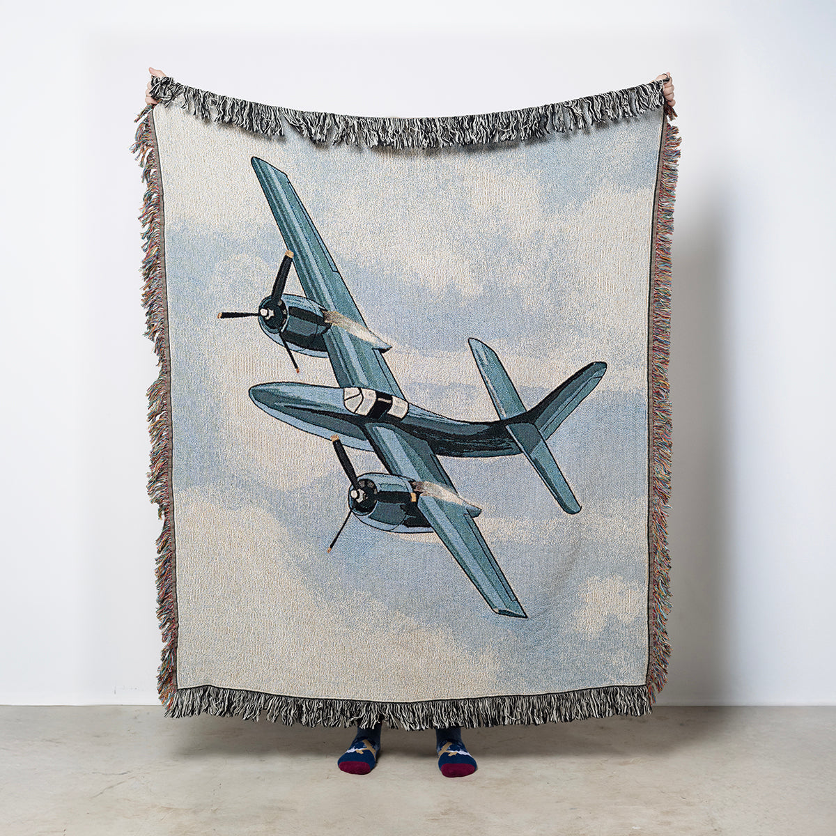 Woven blanket with vintage airplane Grumman F7F Tigercat on a partly cloudy sky background