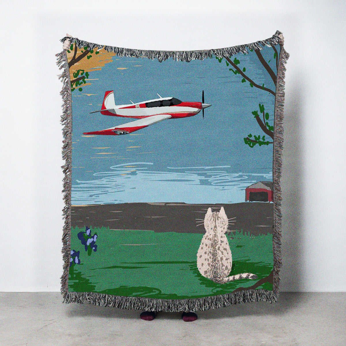 Customizable woven blanket with a scenic design of a cat, airplane, and landscape.