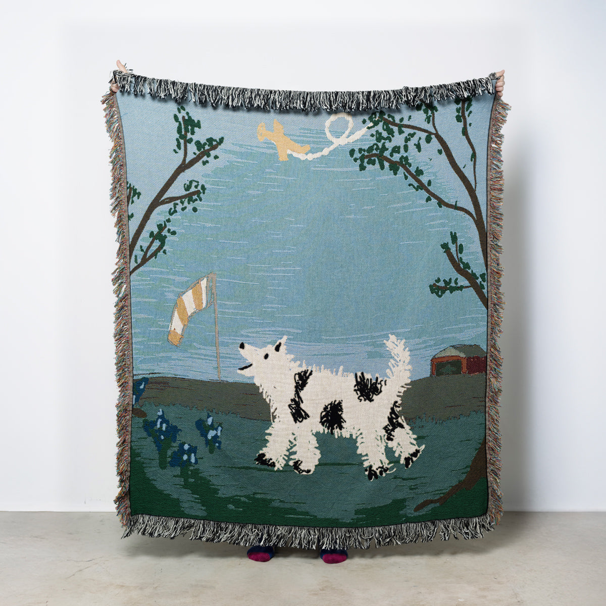 Woven blanket with dog barking at an airplane