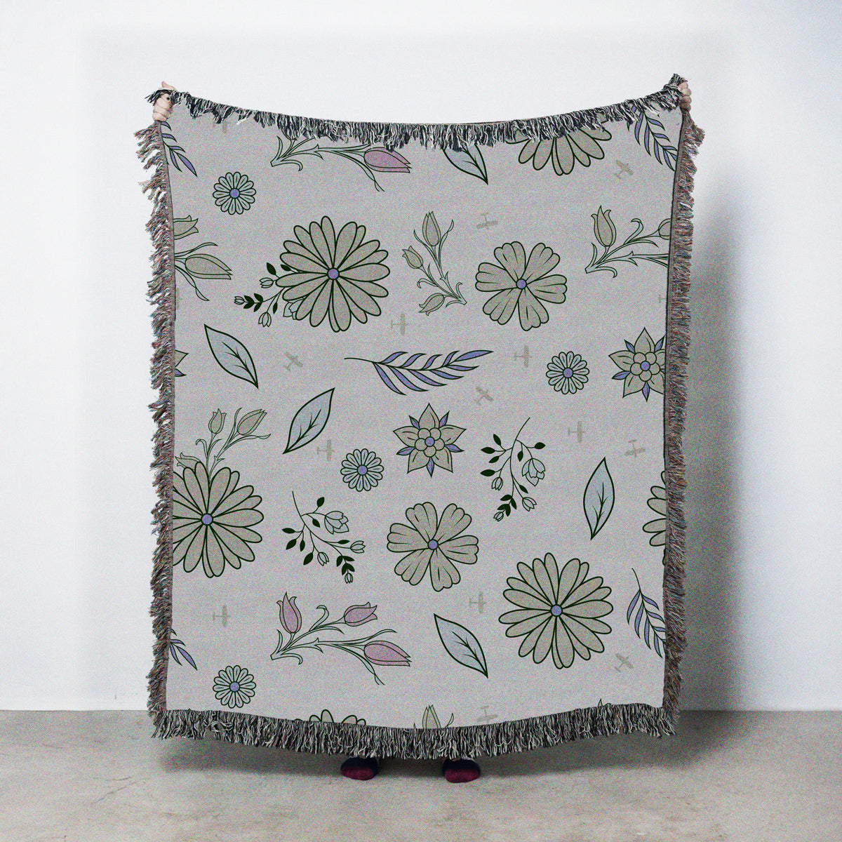 Floral patterned throw blanket with fringe on a cream background